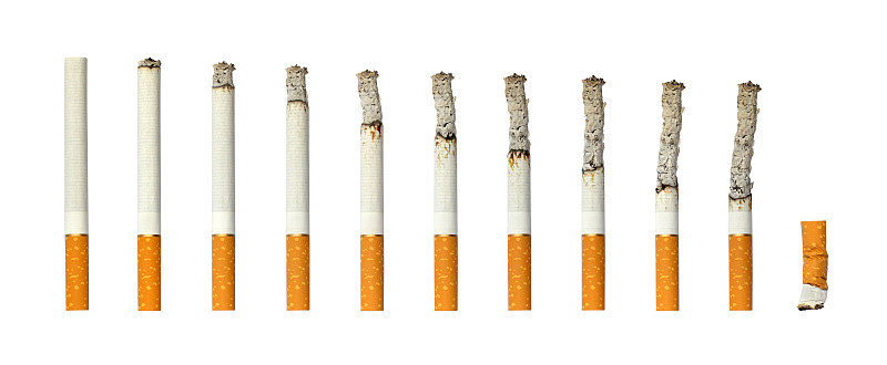 白色孤立的背景上燃烧着的香烟和熄灭的烟头。