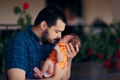 慈爱的父亲在户外抱着新生婴儿