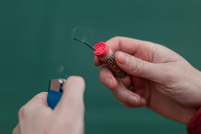 男人在他的手中点燃爆竹