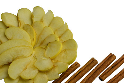 切片的白苹果和肉桂在白色的背景上排成一个圆圈