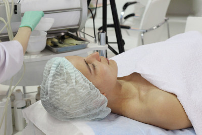 一位年轻女子正躺在美容院的化妆床上。