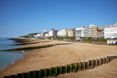 伊斯特本海滩和酒店，东苏塞克斯，英格兰。在英国海滨小镇的海滨与远处的南唐斯的一个夏天的观点。