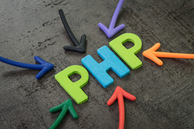 PHP是现代编程语言，用于软件开发或应用程序的概念，多色箭头指向字PHP的黑色水泥黑板墙的中心
