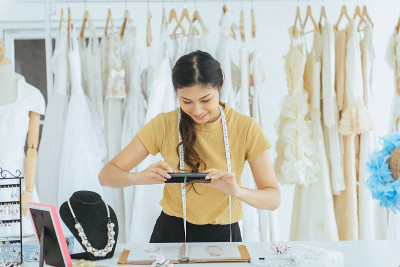 肖像快乐的亚洲女人婚纱店老板正在工作，美丽的裁缝在商店和小企业
