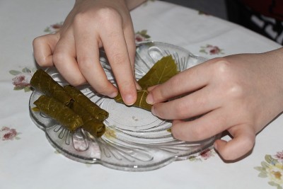一位女士正在用葡萄叶子和肉做一道传统的土耳其菜。