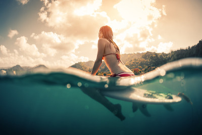 带着冲浪板的年轻女子