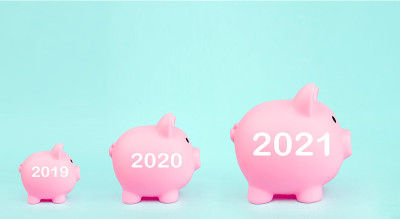 三个粉色储蓄罐，蓝色背景上的数字全息2021年标志。为未来投资和退休而储蓄的概念。