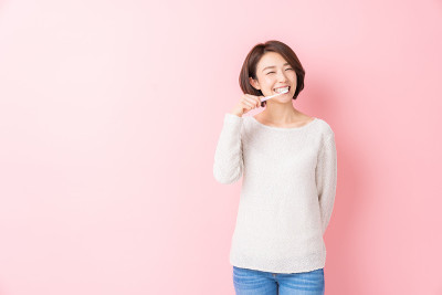 漂亮的亚洲女人用健康的牙齿拿着牙刷，口腔护理