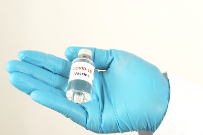 研究人员手中的新冠疫苗女医生手中拿着注射器和注射免疫疫苗的药瓶。”