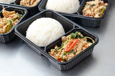 塑料包装的泰国食物午餐盒，罗勒炒猪肉和米饭(Pad Ka Prao)。