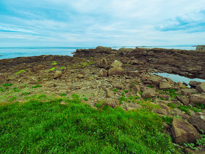 风景优美的海滩，岩石和草在波特拉什海岸，在夏天的上午时间，北爱尔兰