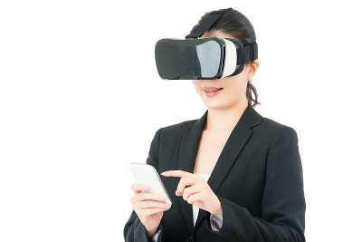 亚洲商务女性使用智能手机控制VR耳机