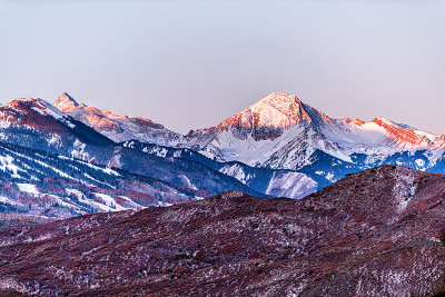 阿斯彭，科罗拉多州五颜六色的蓝色日出阳光在国会大厦和雪山山顶的近剪影在秋天秋天的季节