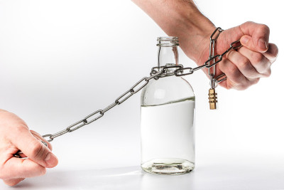 一瓶酒精绑在两只手上的金属链子上