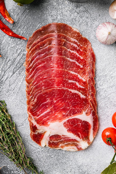 Coppa, Capocollo, Capicollo meat，在灰色的石头桌子背景上，顶视图平放