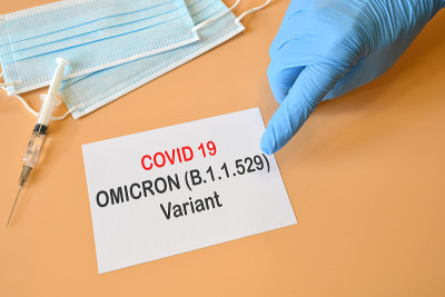 Covid-19新的欧米克隆变种。戴着蓝色手套的医生手上写着“Covid-19变种Omicron”。