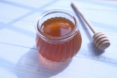 蜂蜜在一个罐子在白色的桌子上的特写