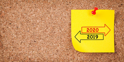 黄色贴纸，上面写着旧年或2020年，软木板上有红色的大头钉