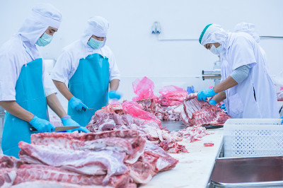 在工厂里切肉的工人