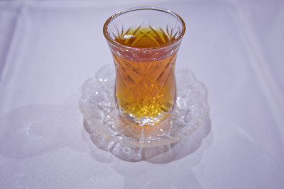 阿塞拜疆传统armudu茶梨形玻璃杯。阿塞拜疆红茶与复古的白色桌子。土耳其黑茶梨形杯，阿塞拜疆传统芳