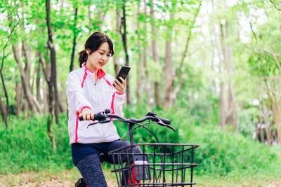 一位女士一边骑自行车一边用手机