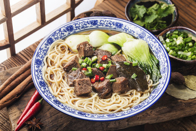 麻辣红汤牛肉面放在木桌上的碗里