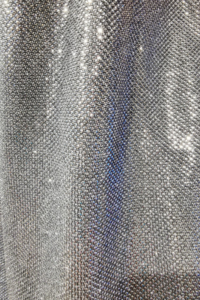 Silver fabric made of a grid of sparkling sequins.