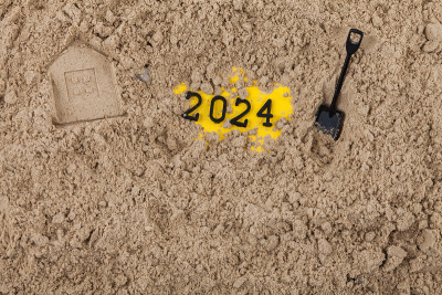 新年的概念2024在湿沙上挖铲子揭示新的一年