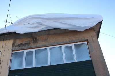 从屋顶上滑落下来的大雪危险地悬在窗户上