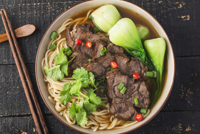 麻辣红汤牛肉面放在木桌上的碗里