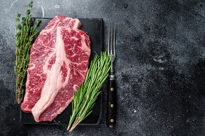 生的Striploin牛排或纽约牛排牛肉切。黑色背景。前视图。本空间