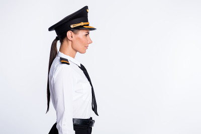 资料照片相当成功的女士看空空间戴帽飞行员制服孤立的白色背景