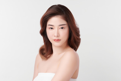 美丽年轻的亚洲女性与干净的新鲜皮肤在白色的背景，面部护理，面部治疗，美容和水疗中心，亚洲女性肖像。