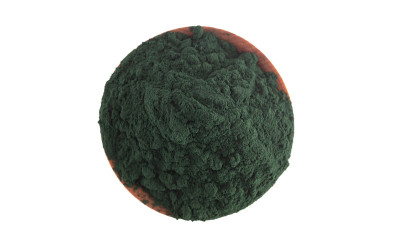 一个装满螺旋藻粉的木碗，白色背景