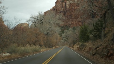 公路旅行，在锡安峡谷驾驶汽车，犹他州，美国。在美国搭便车旅行，秋天之旅。红色外星人陡峭的悬崖，雨水和