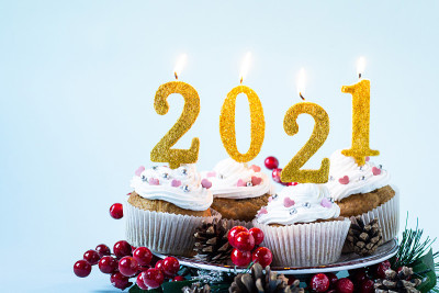 2021年新年快乐纸杯蛋糕和点燃的蜡烛。圣诞快乐，冬季问候概念。本空间