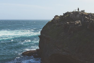 一个男人站在悬崖上望着大海。