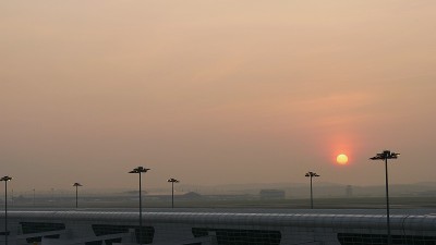 吉隆坡国际机场上空升起的大圆太阳，宽镜头。