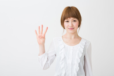 年轻有魅力的亚洲女人指着数字4