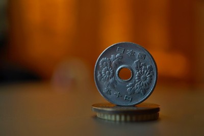 宏观细节的金属日本硬币(日元)在柱的顶部创造的硬币与积极的彩色温暖的背景