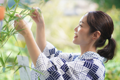 在七夕竹子上贴纸条的女人