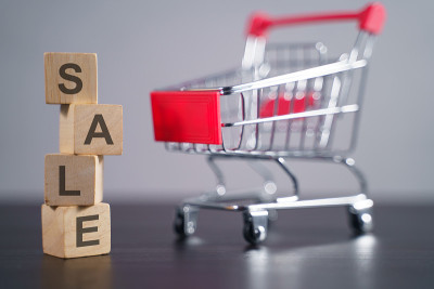 带购物车的木制立方体上显示“SALE”字样。