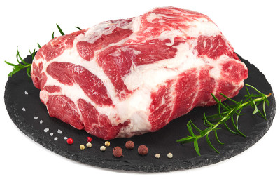 生猪肉与迷迭香和胡椒在黑色圆形石盘上孤立在白色背景。裁剪路径和全景深