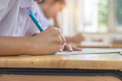 学生在高中、亚洲考场、测试或考试中使用钢笔在白纸上写信息是评估的目的是衡量知识、技能、能力倾向、教育