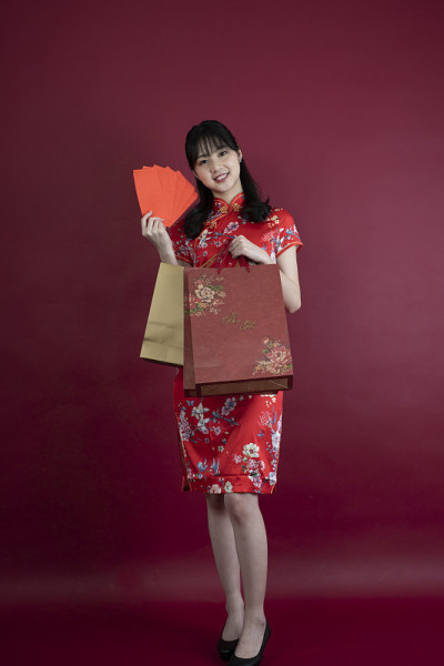 快乐的亚洲年轻女子展示红包庆祝中国新年