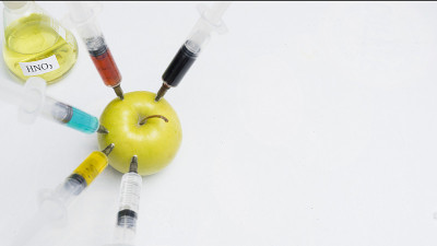 杀虫剂、硝酸盐、转基因和其他化学物质被用注射器注射到一个青苹果中。