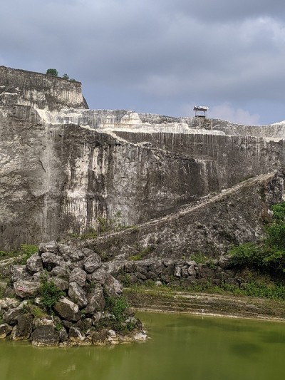 白色的砖采石场和流行的背景与石灰岩悬崖和在池塘里划船的照片。
