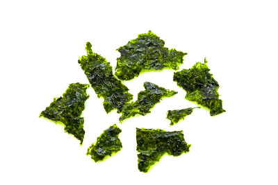 绿色的海藻片，孤立在白色的背景上。韩国健康小吃、健康食品。特写镜头。