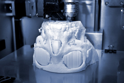 3D打印机打印出熔融塑料白色的形状。
