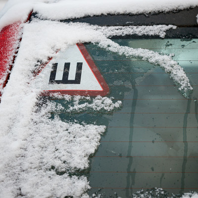 汽车后窗上镶嵌轮胎的标志。在积雪的道路上安全行驶
